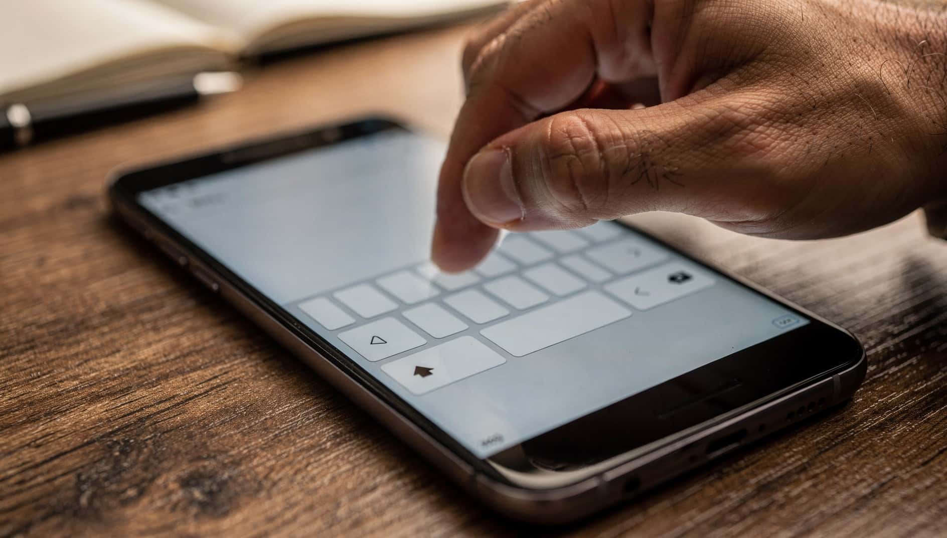 Dedo que pulsa una tecla del teclado en pantalla de un móvil Android