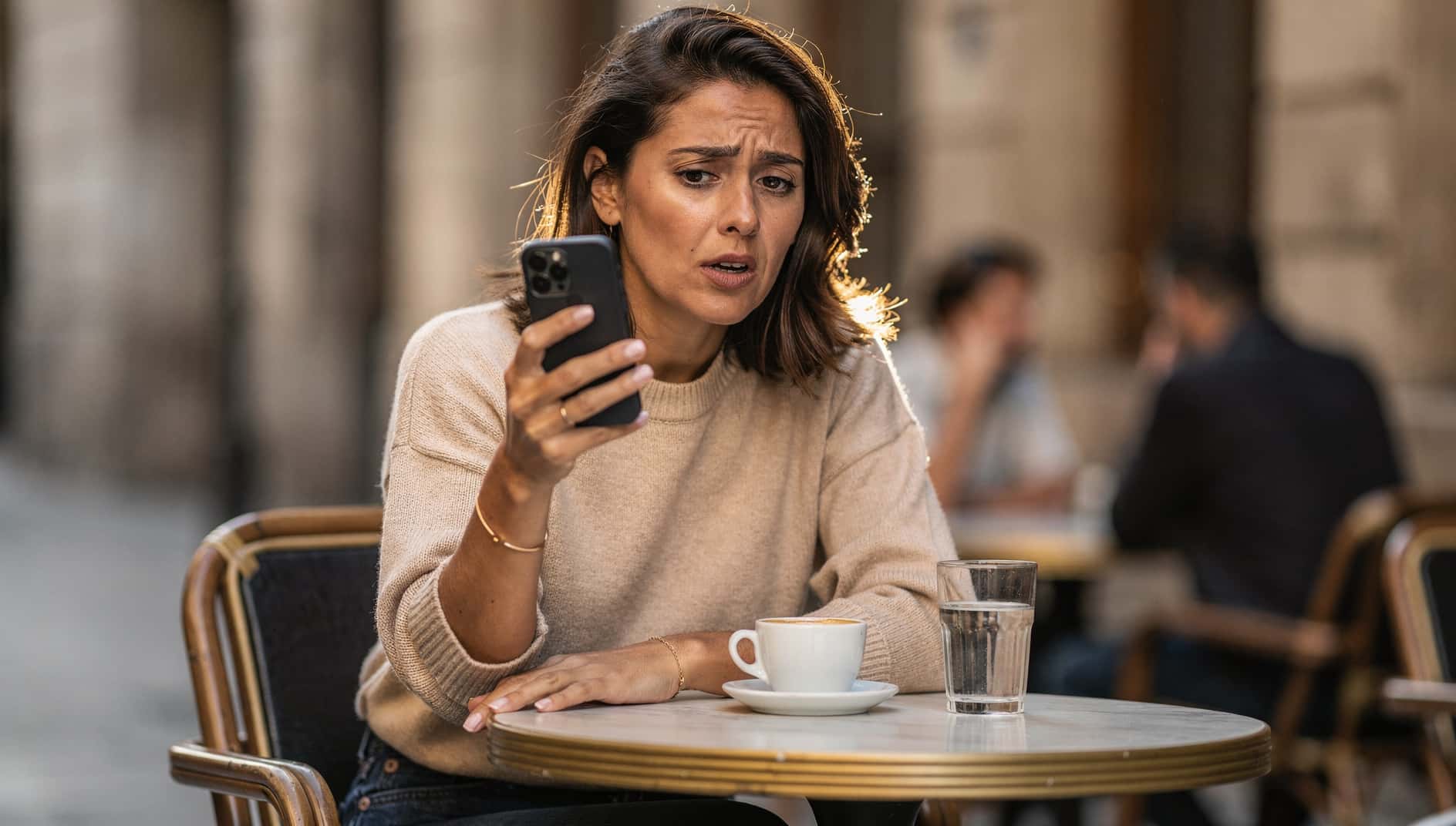 Mujer en una cafetería mirando extrañada su móvil Android porque Google no funciona