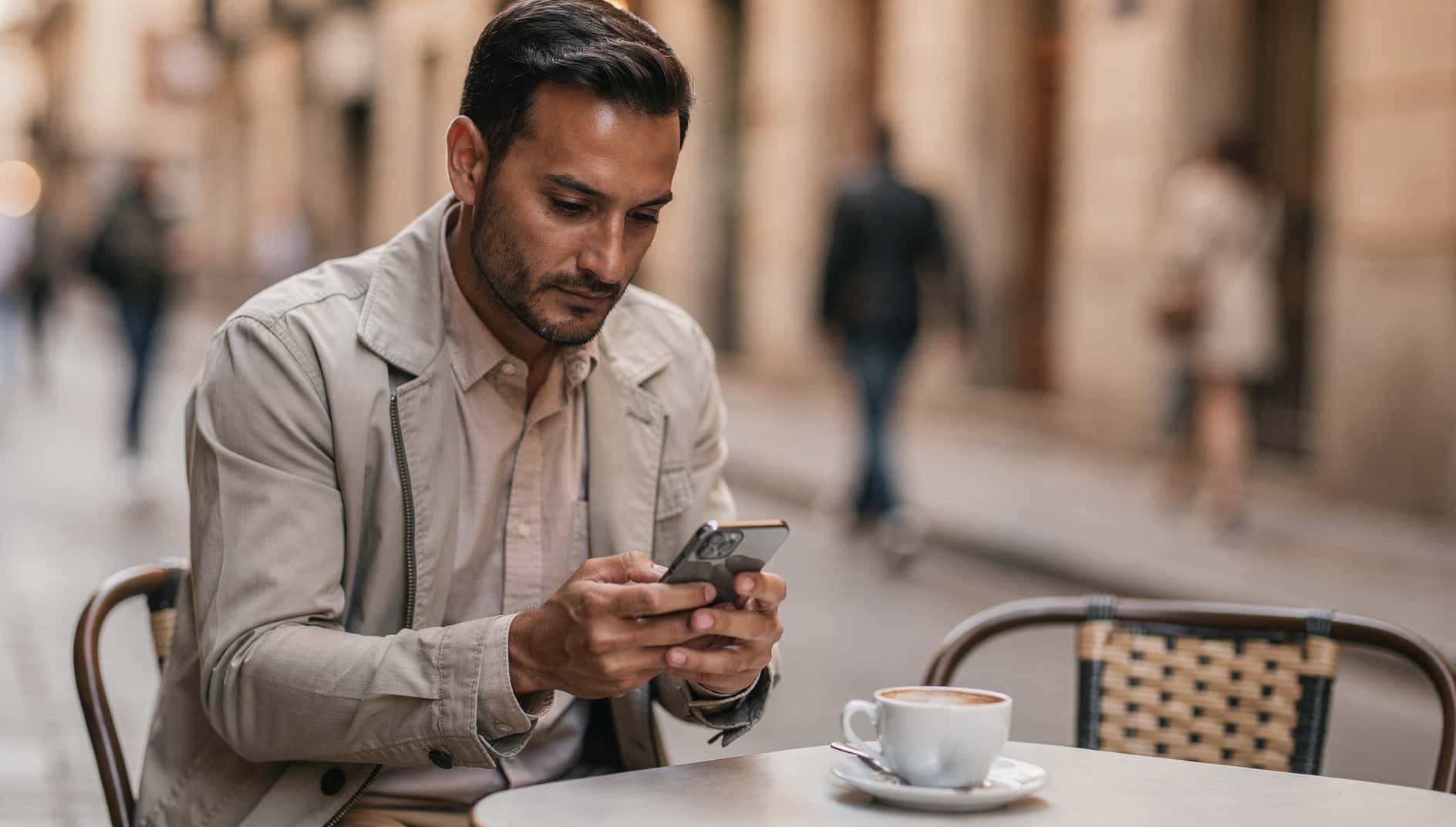 Un hombre en una cafetería revisa los ajustes de su móvil Samsung